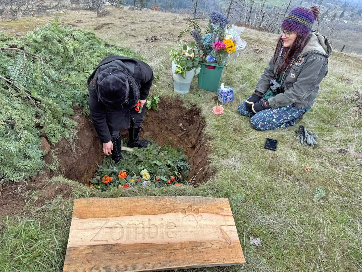 Pet owner decorates inside grave at Paws in Peace pet cemetery at Great River Natural Burial