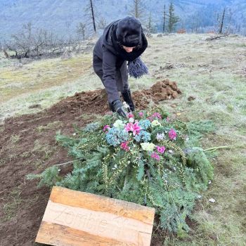 Pet owner decorates grave at Paws in Peace pet cemetery at Great River Natural Burial