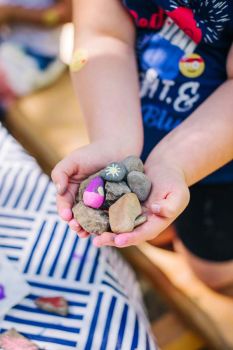 summer camp student holds hand-painted rocks