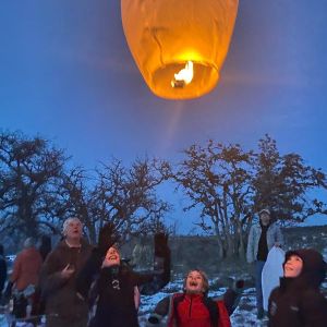family releases floating sky lantern at dusk